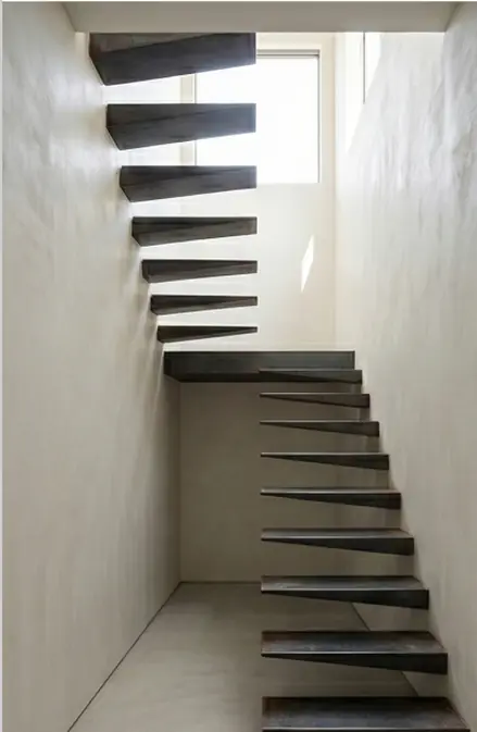 Trémie d’un escalier flottant en acier vue depuis le bas